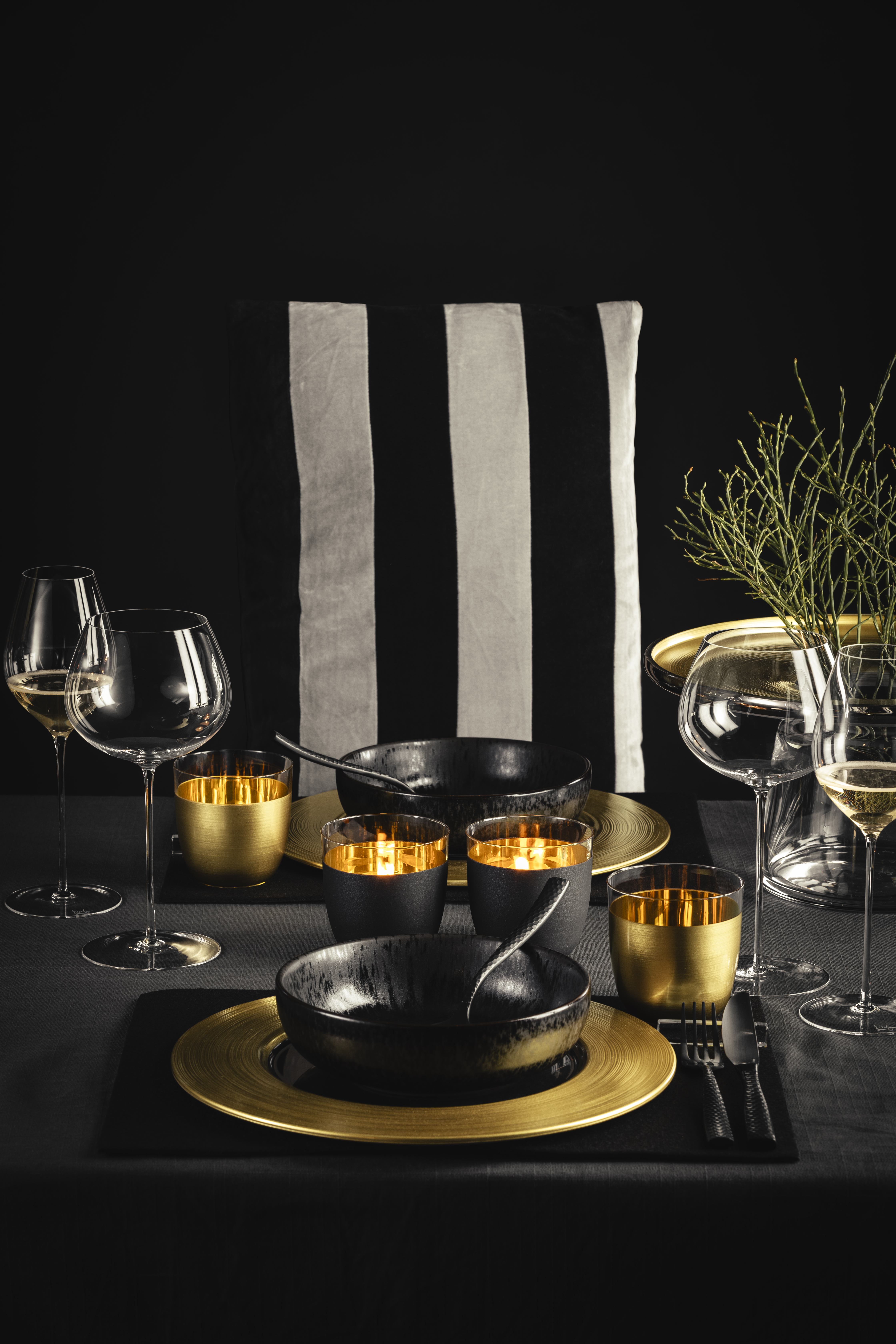 Tischszene mit gold/schwarzen Gläsern und schwarzen Tellern