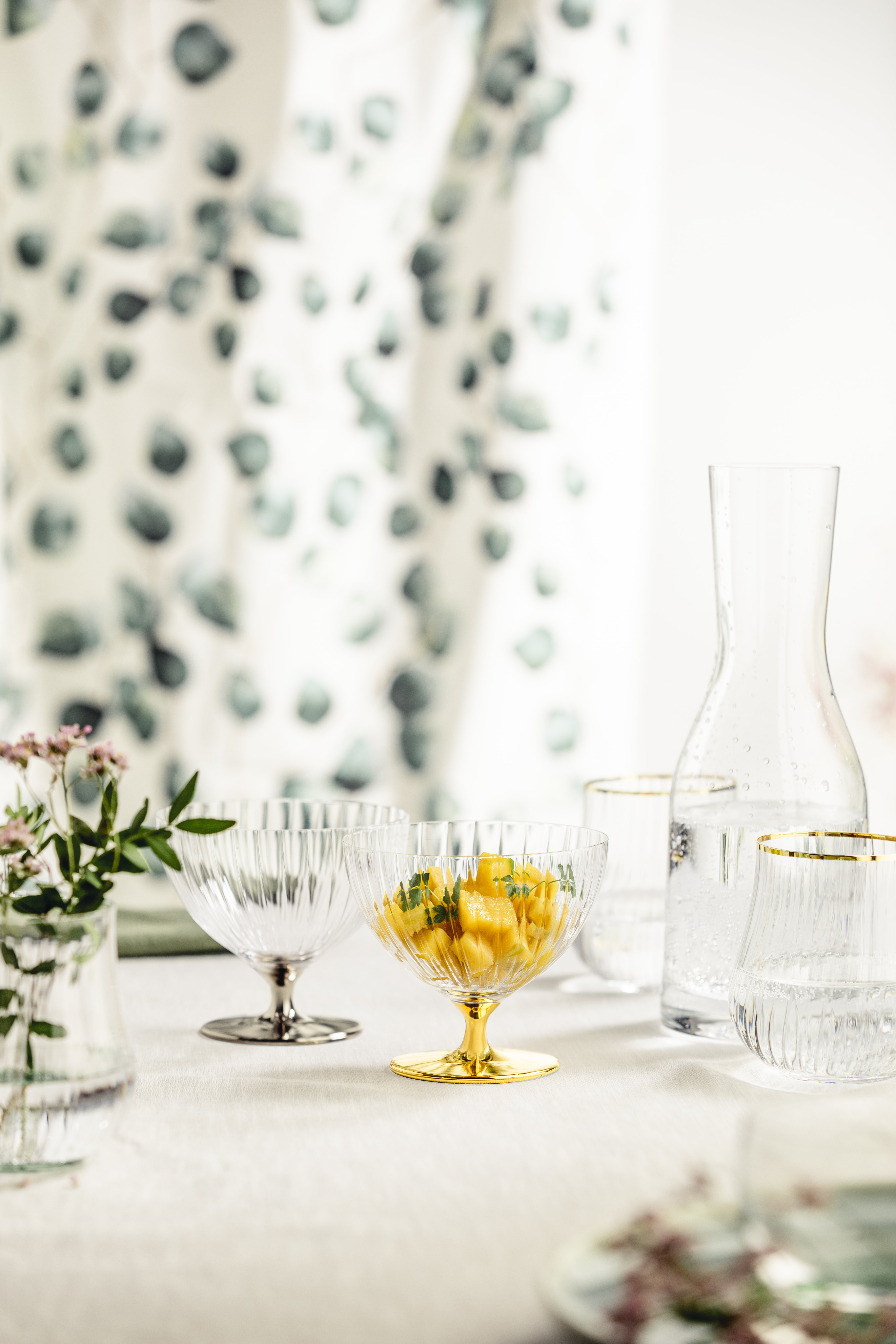 Golden and platinum-coloured dessert bowl on a table with carafe