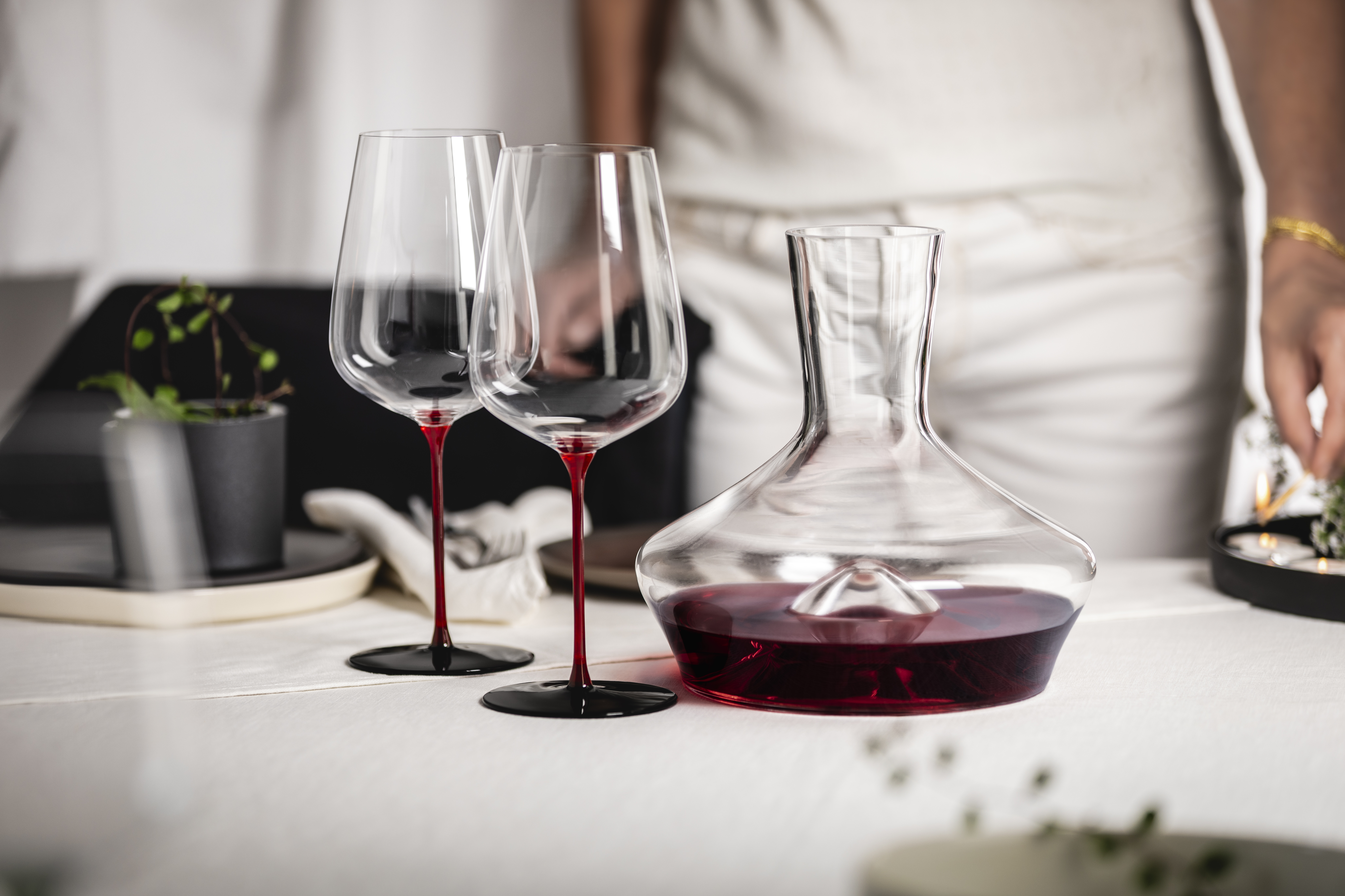 Two red-stemmed wine glasses and a decanter