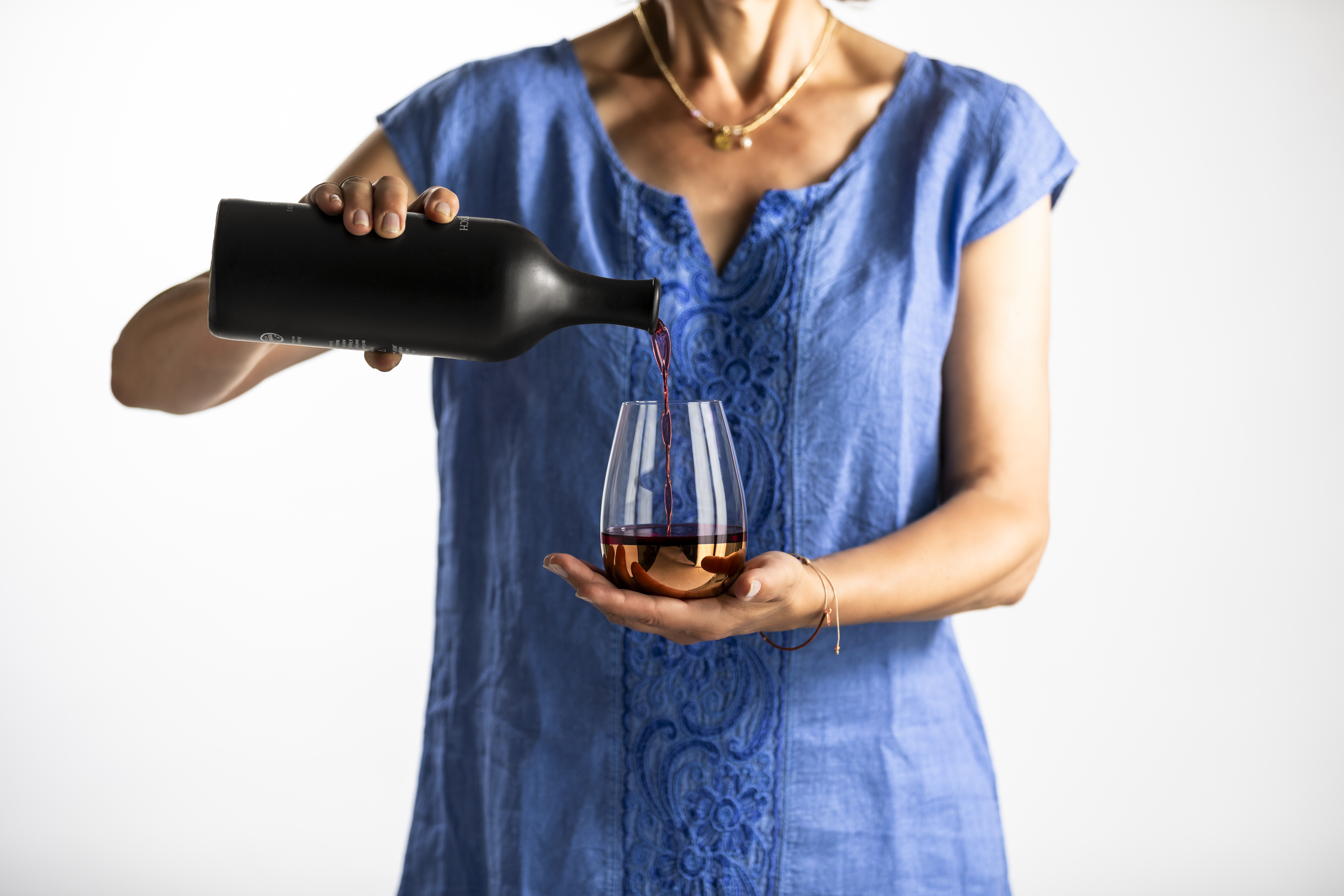 A person pours wine into a copper-coloured glass from the Elevate series.