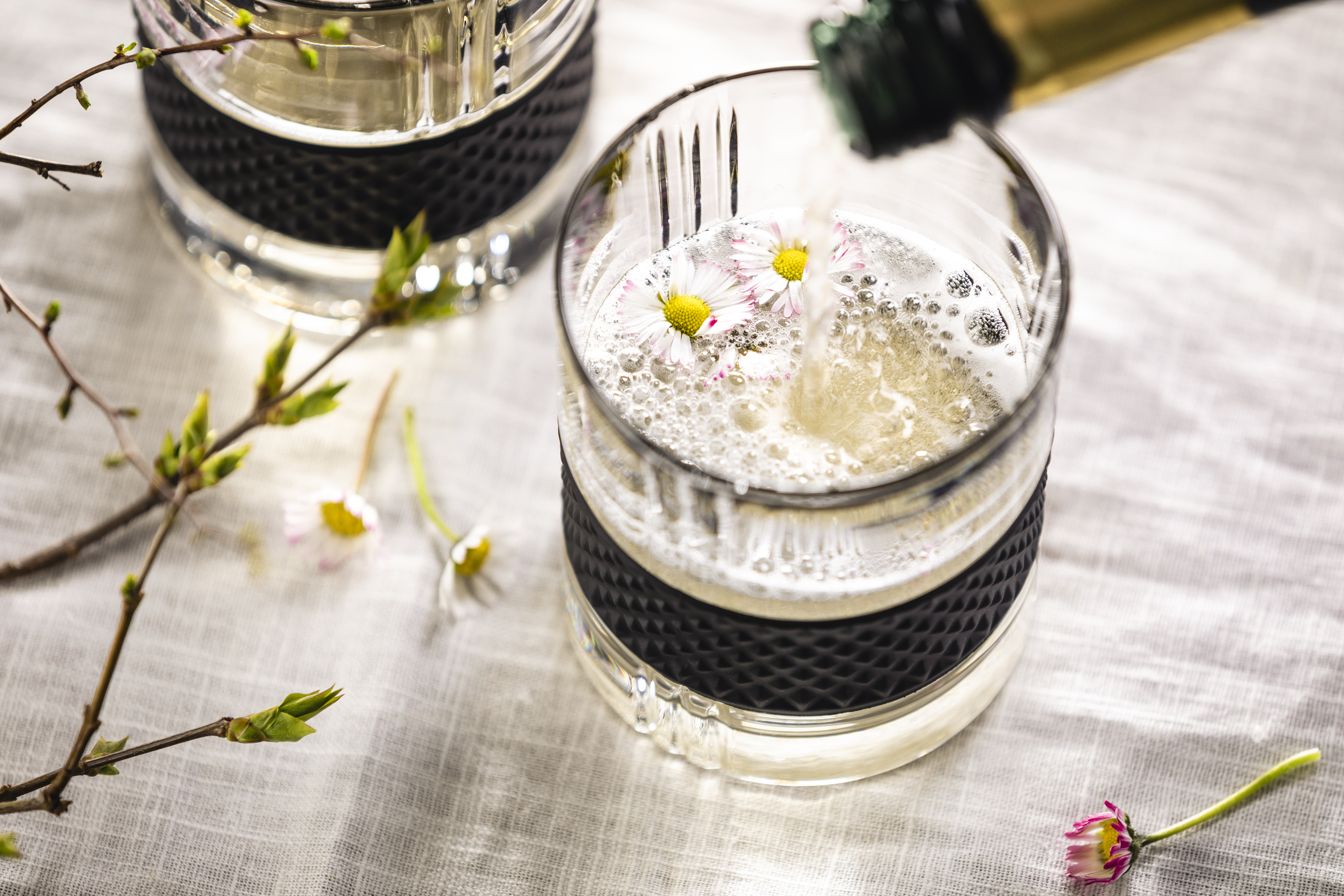 Glass filled with sparkling wine and daisies as decoration