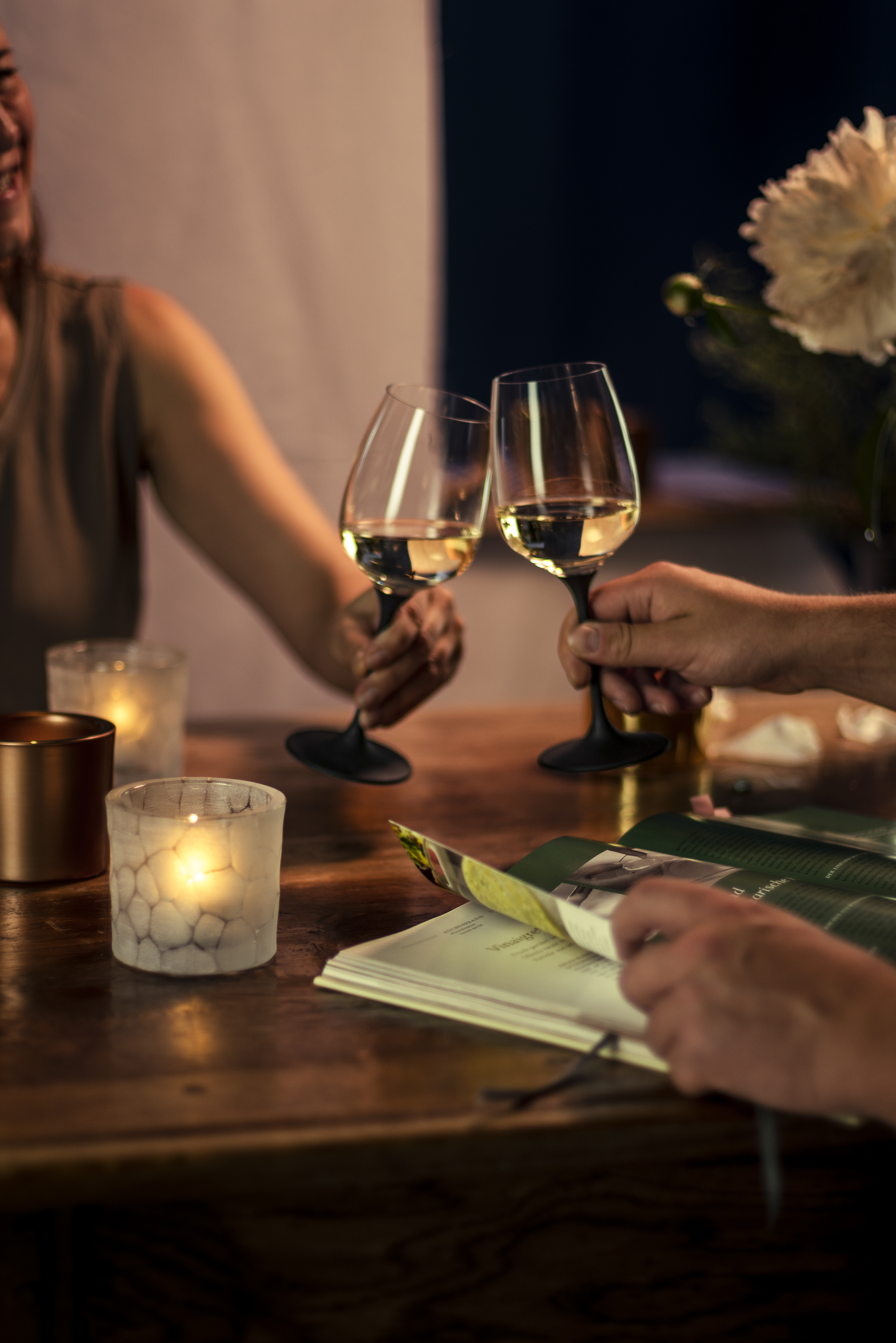 Two people clink wine glasses