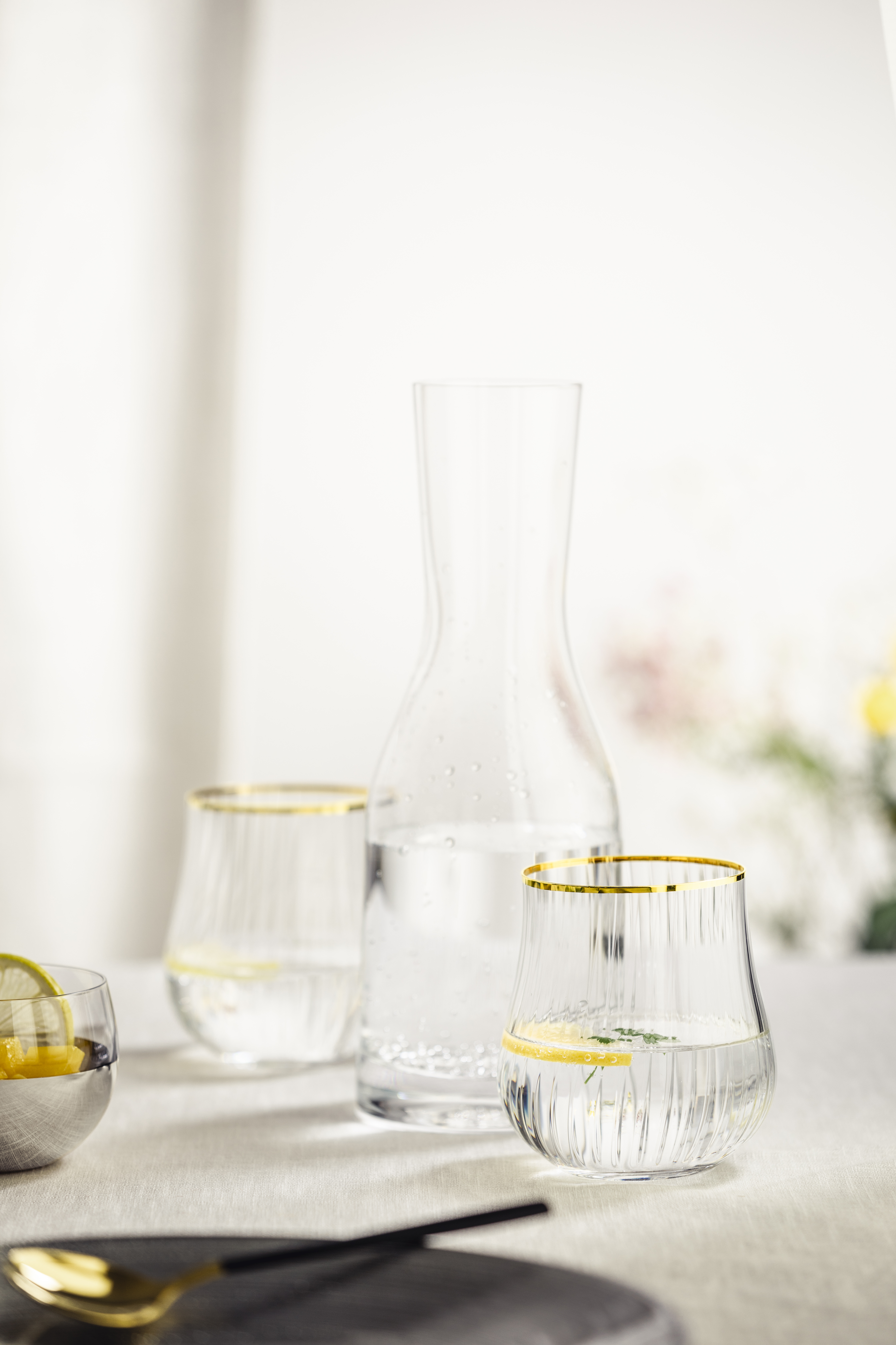 Carafe with cork stopper and two cups on table