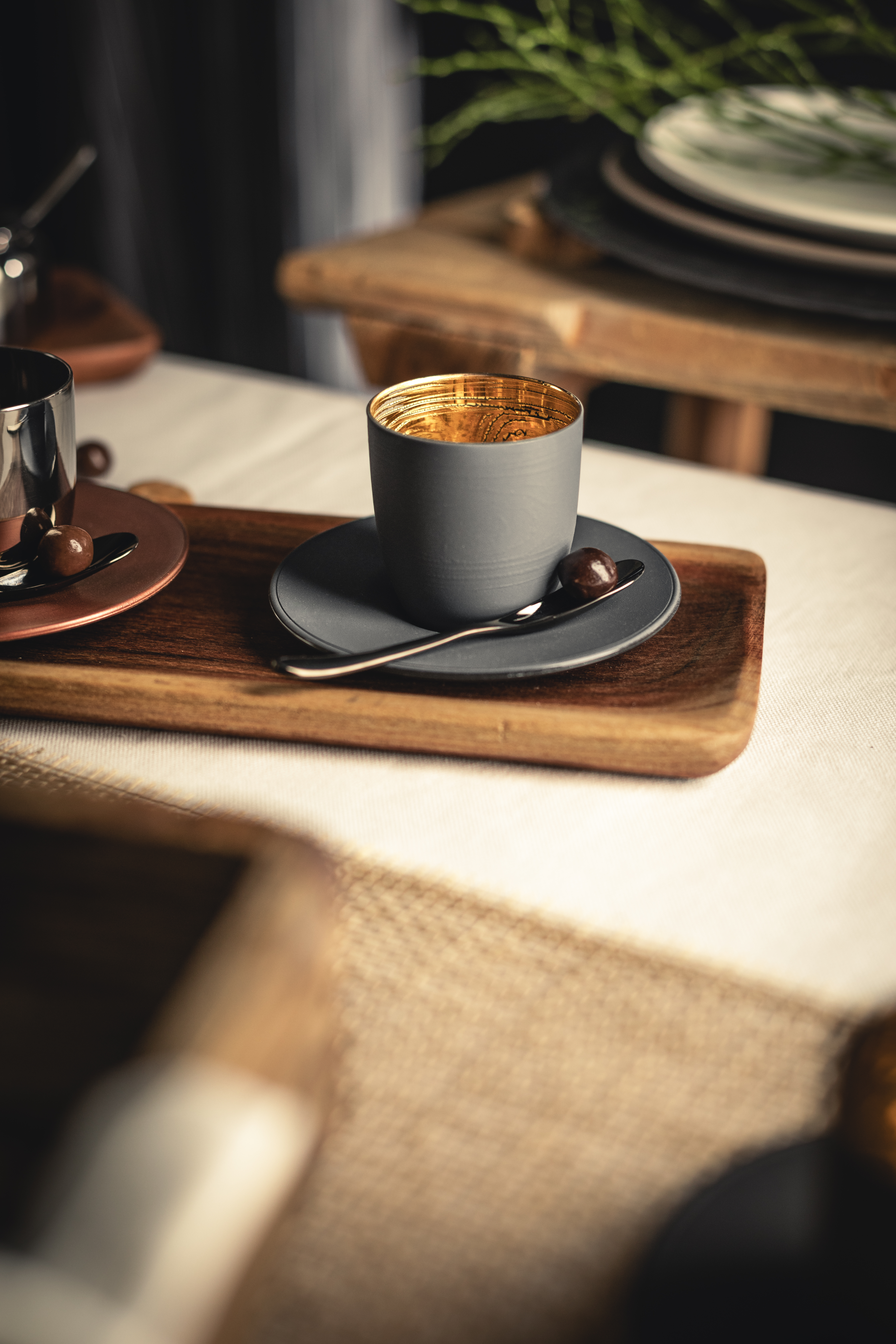Black and gold espresso glass on wooden tray