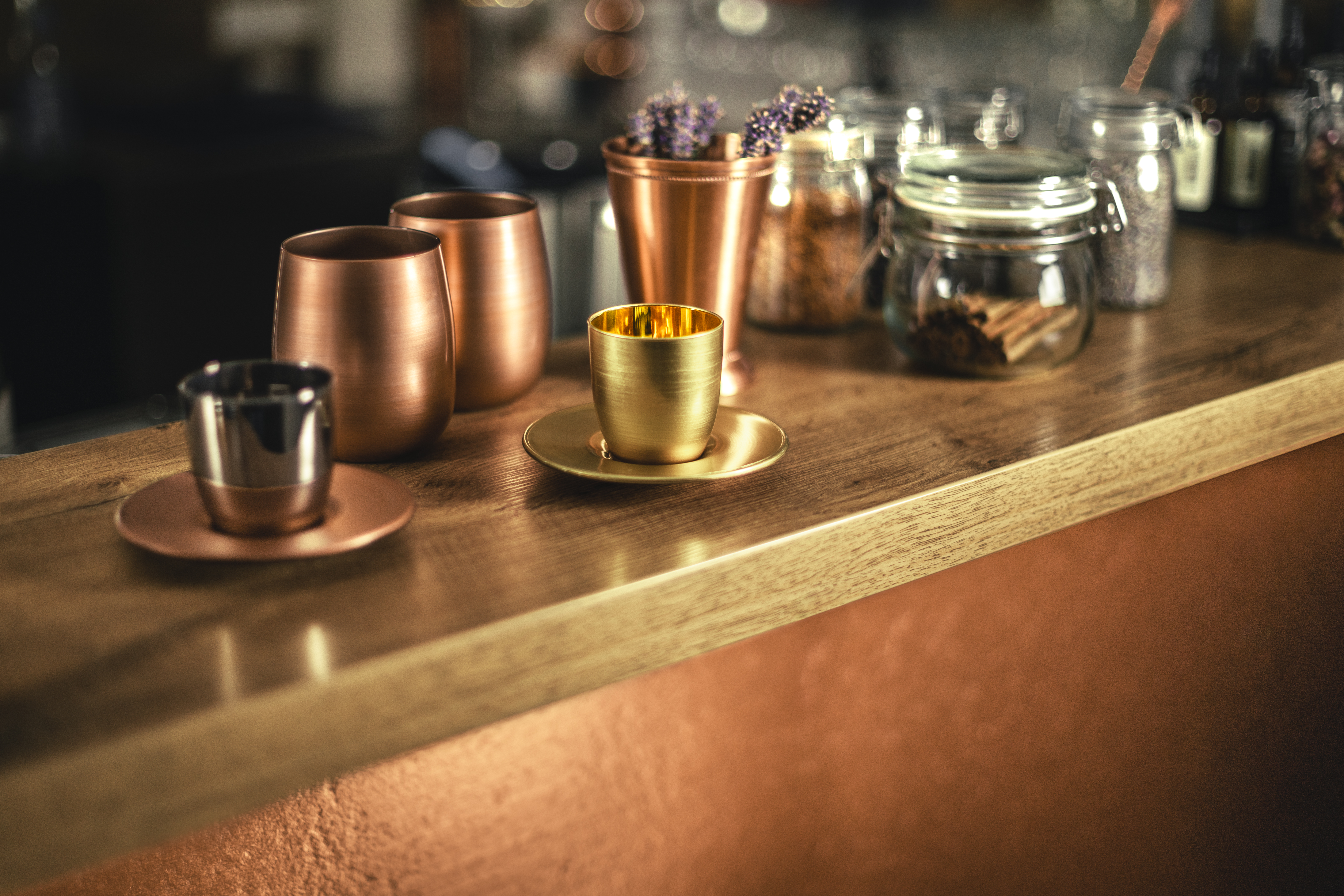 Gold and copper-coloured espresso glasses on bar