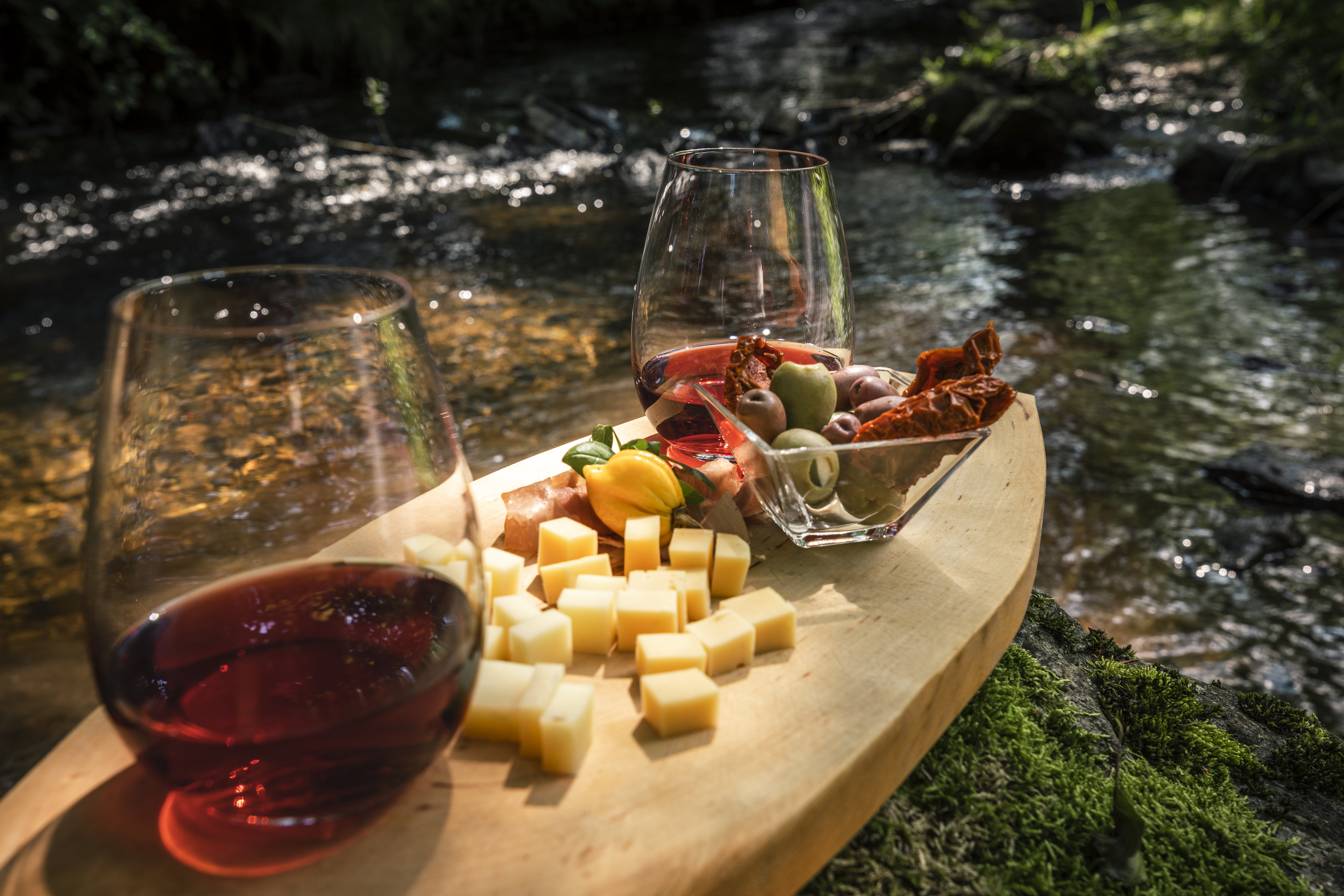 Two cups stand on a board by a river