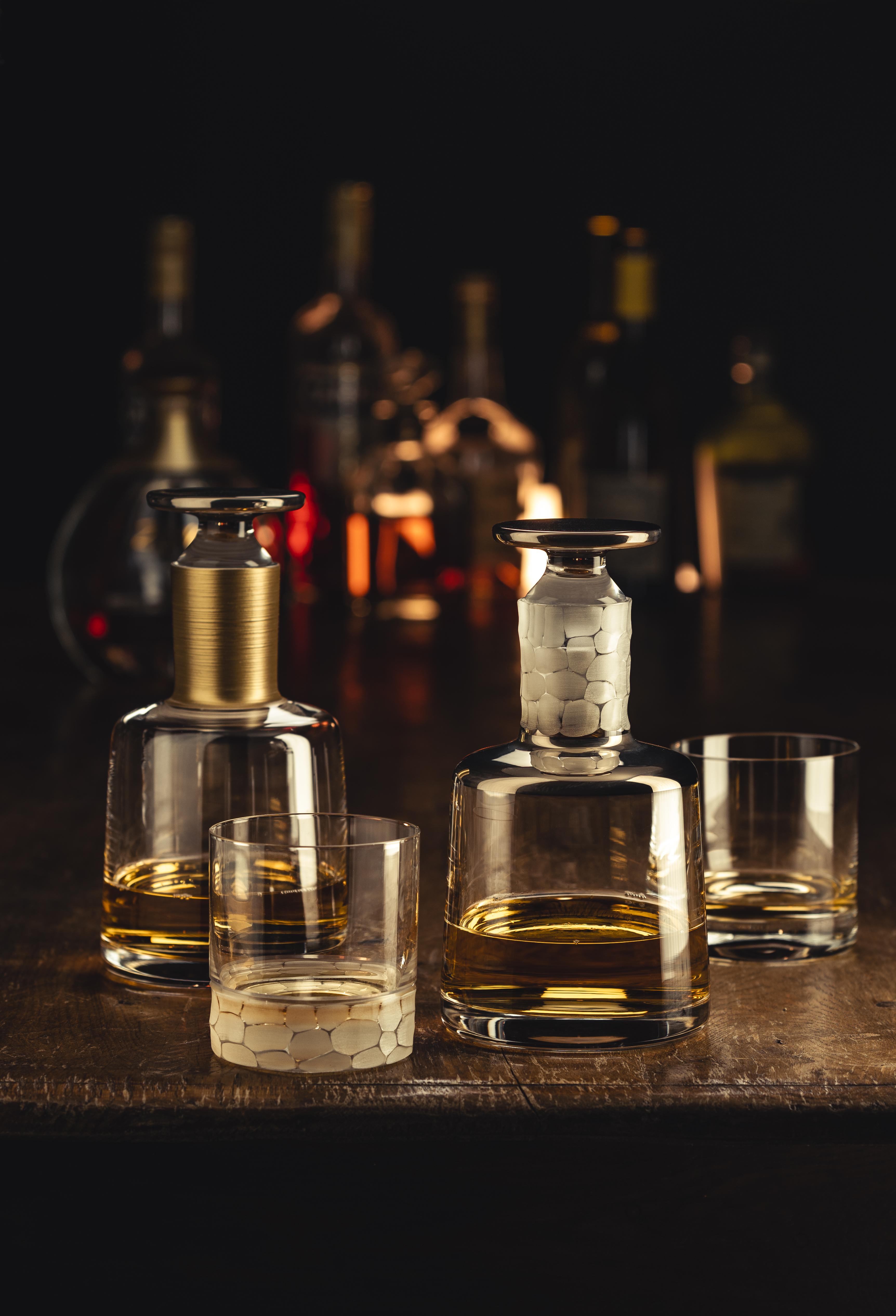 Verschiedene Whiskykaraffen und Gläser in Barszene