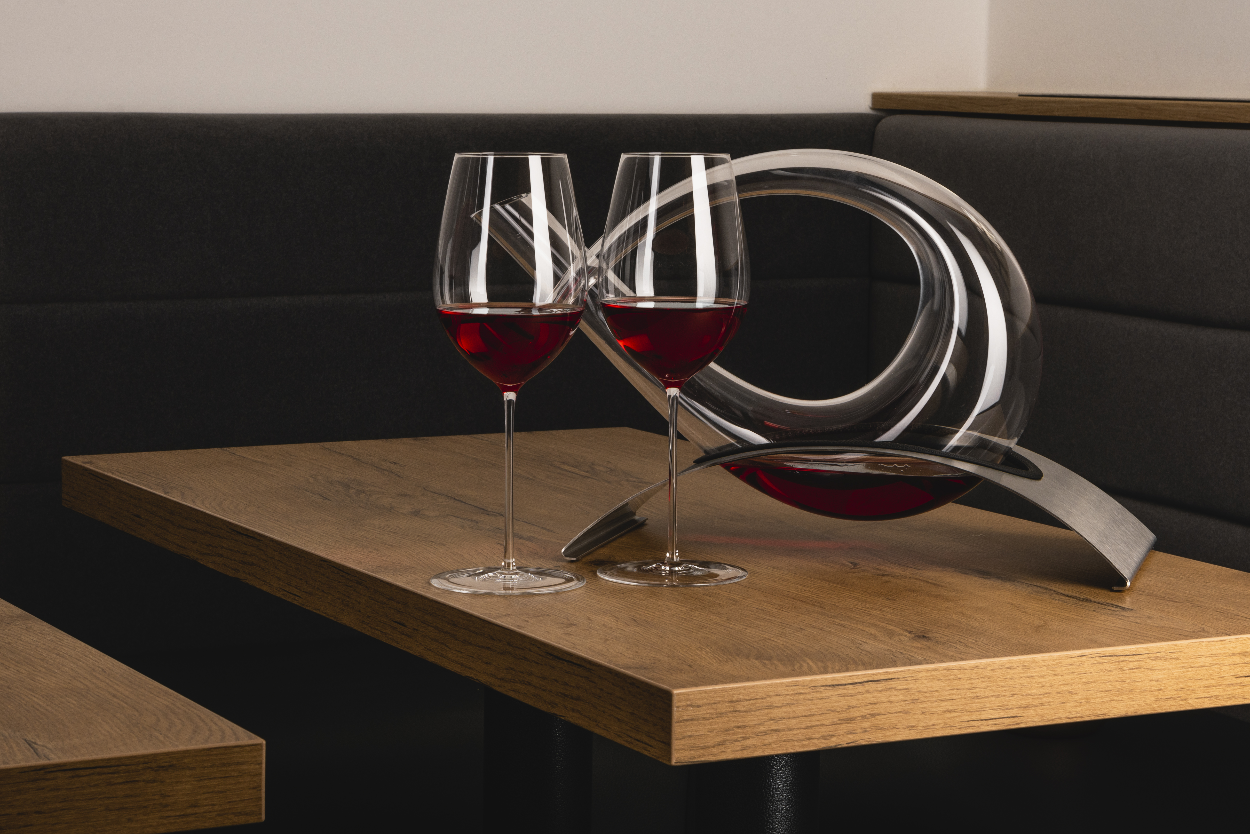 Two wine glasses with Edition 1 decanter on a table