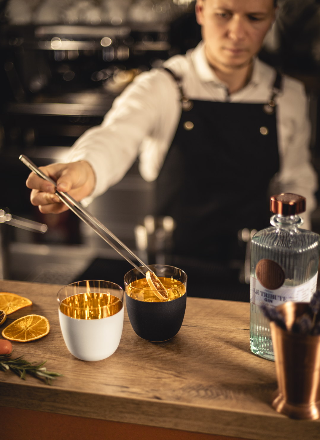 Bartender adds orange slice to drink