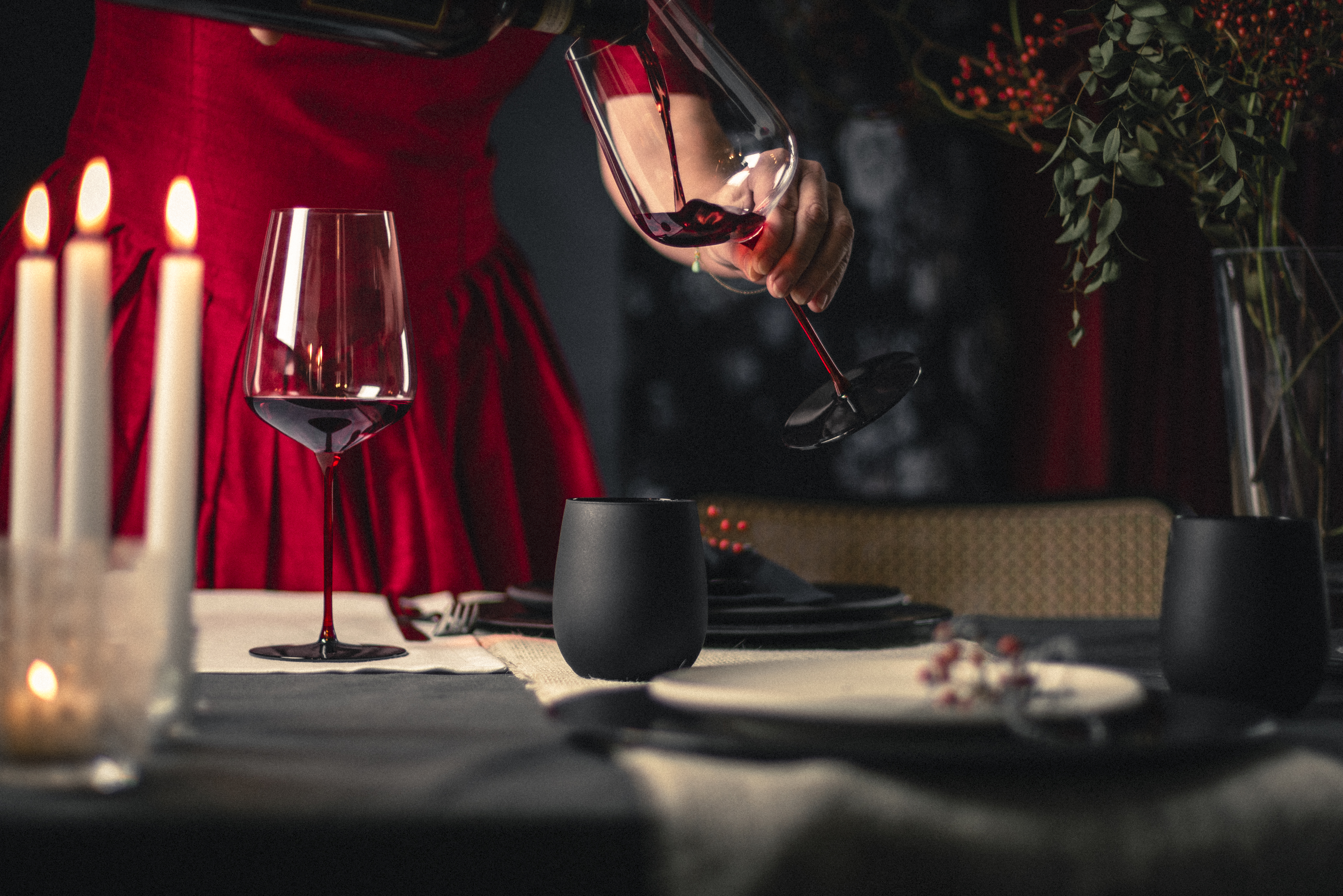 Red and black table decorations with wine glasses with red stems