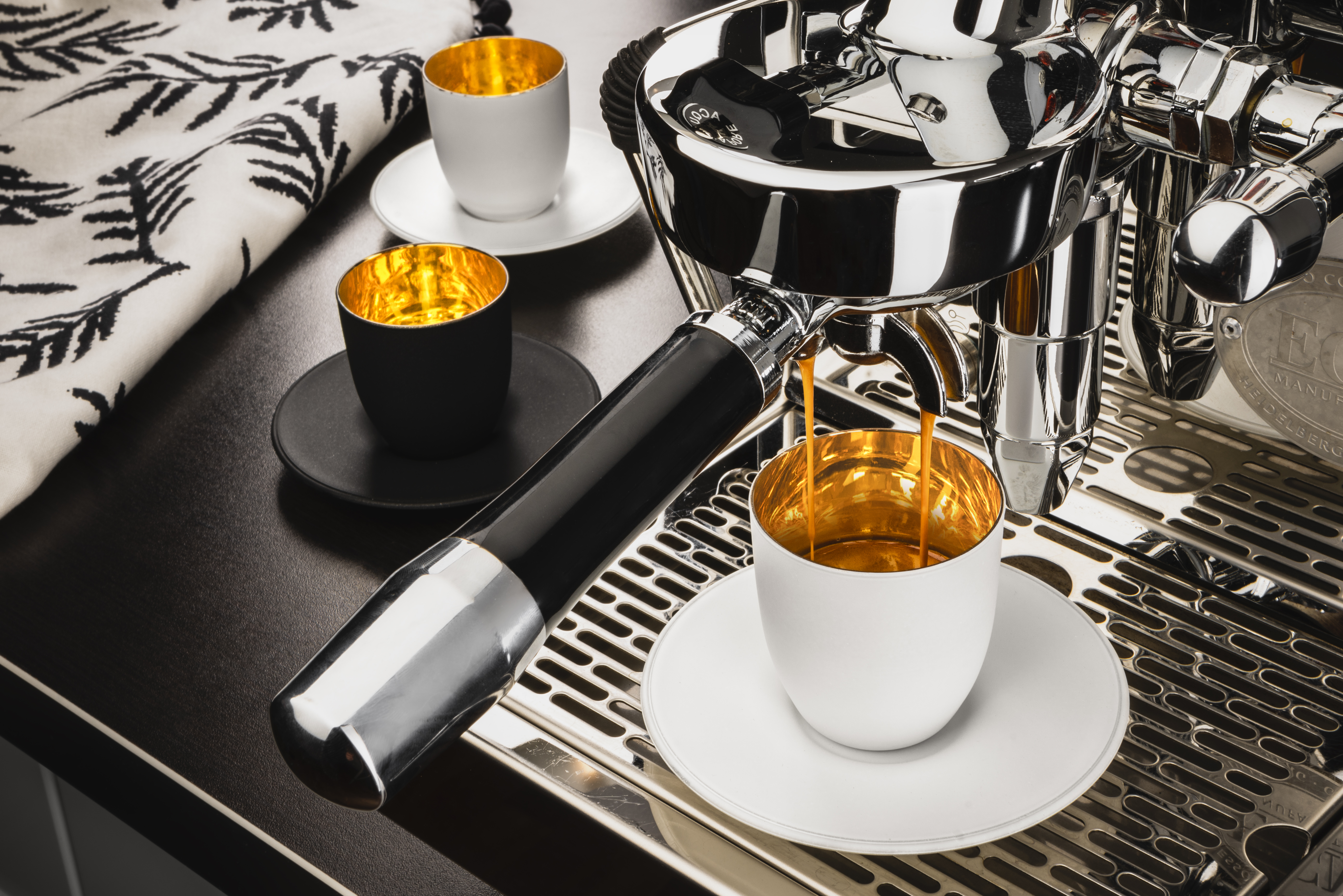 Gold/black/white espresso glasses in coffee machine