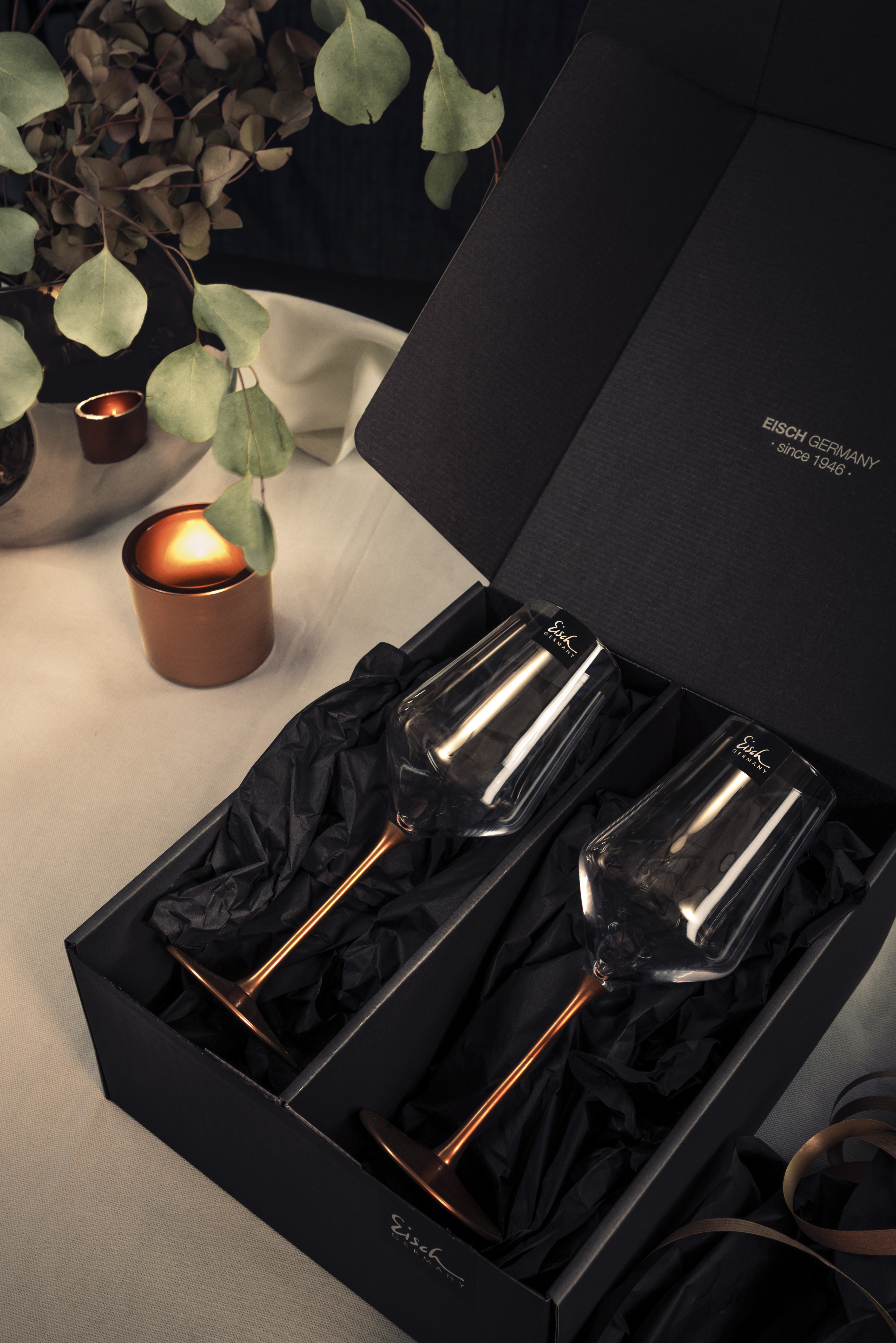 Two wine glasses with copper stems and gift packaging