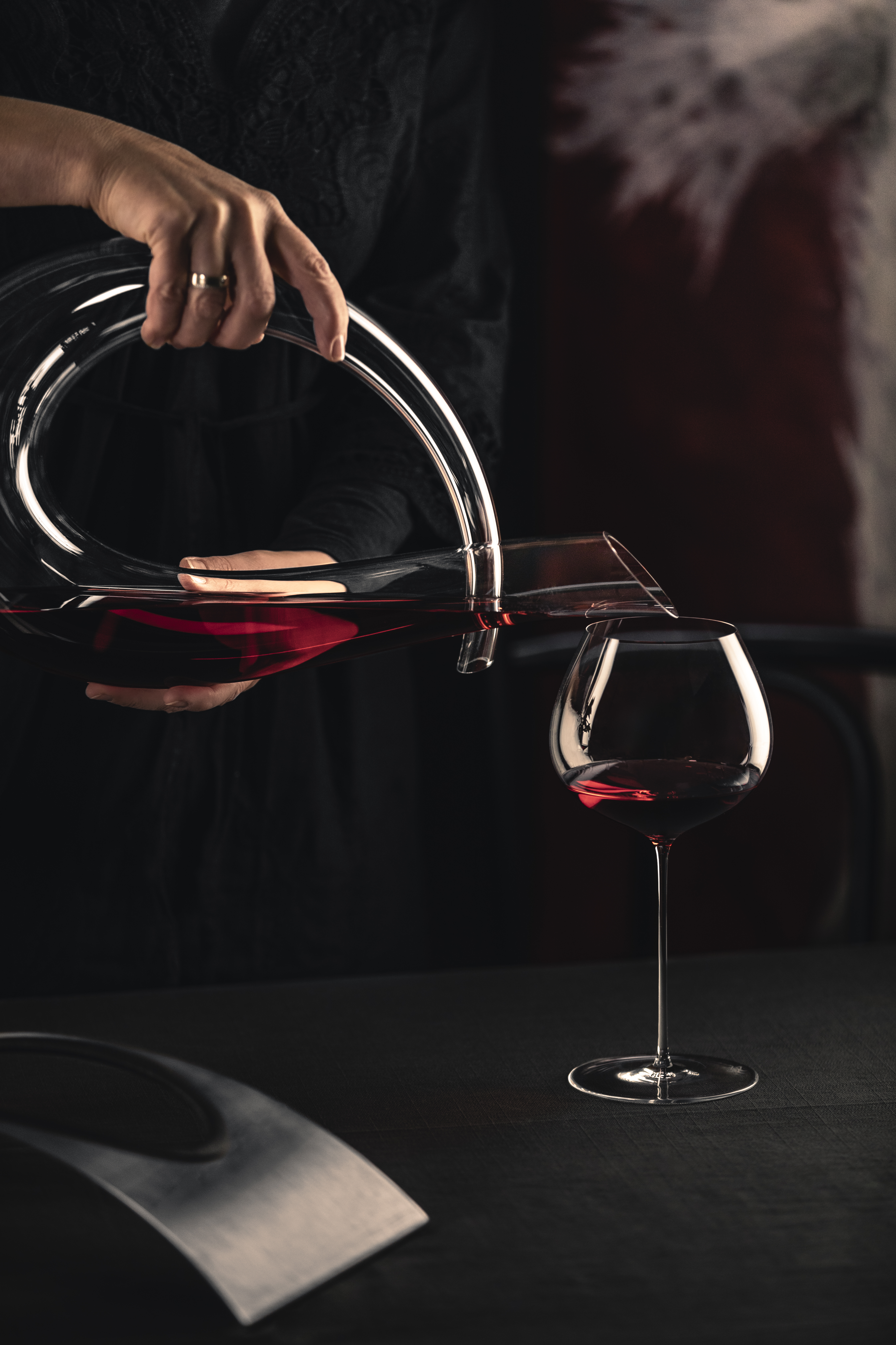 Decanter being filling a glass by eisch with wine