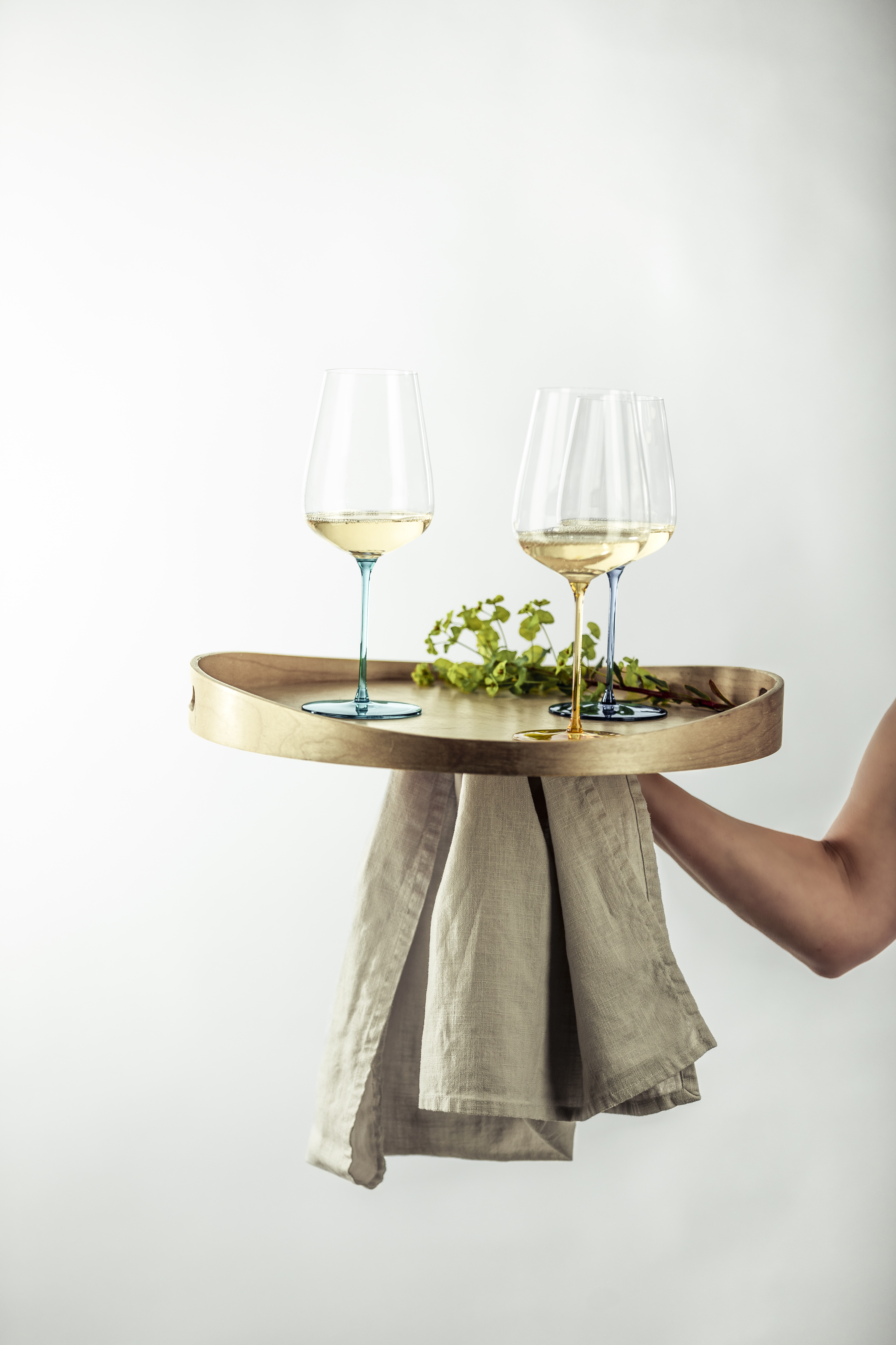 Three coloured wine glasses filled with white wine on a tray