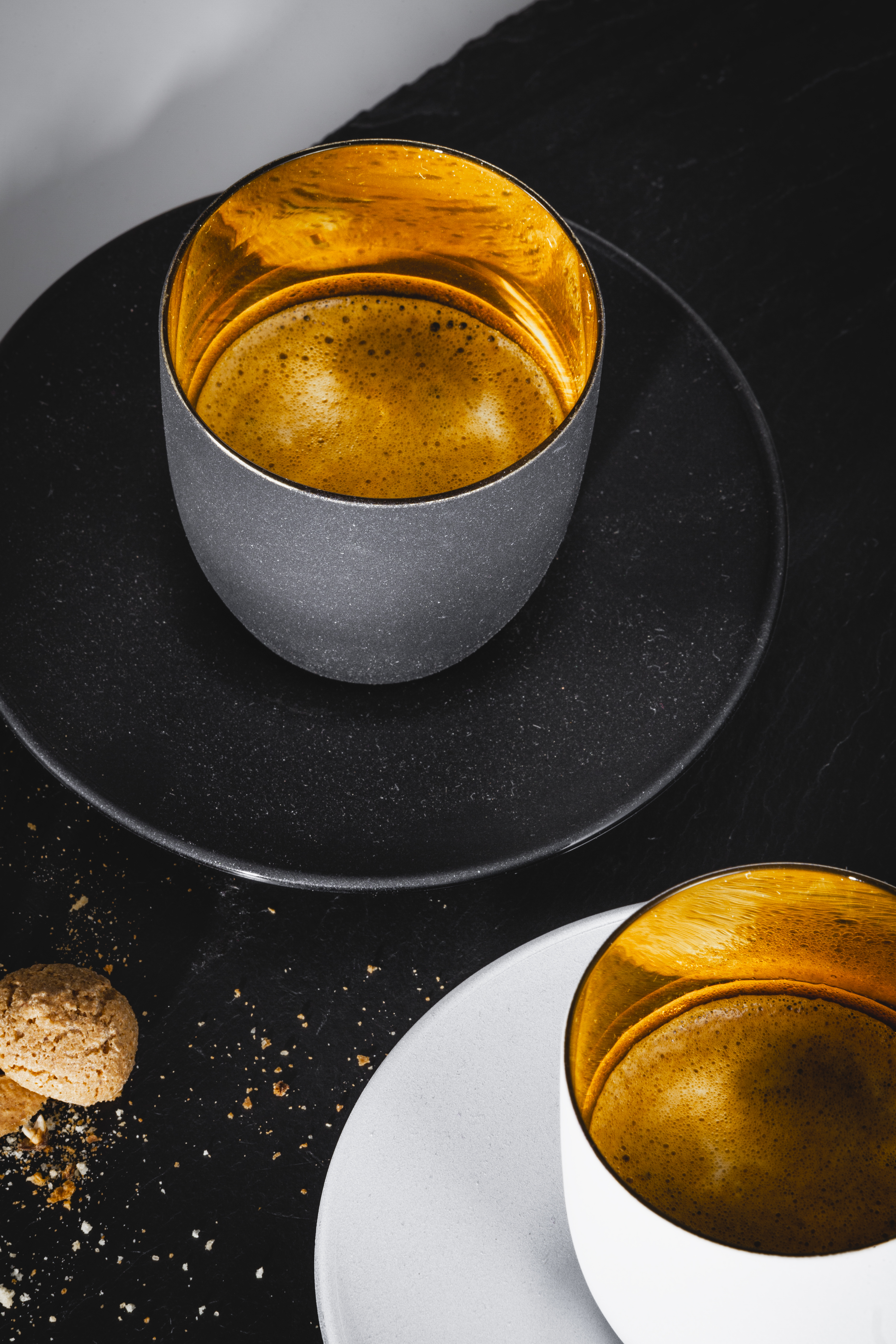 Schwarzes und weißes  Espressoglas mit Espresso