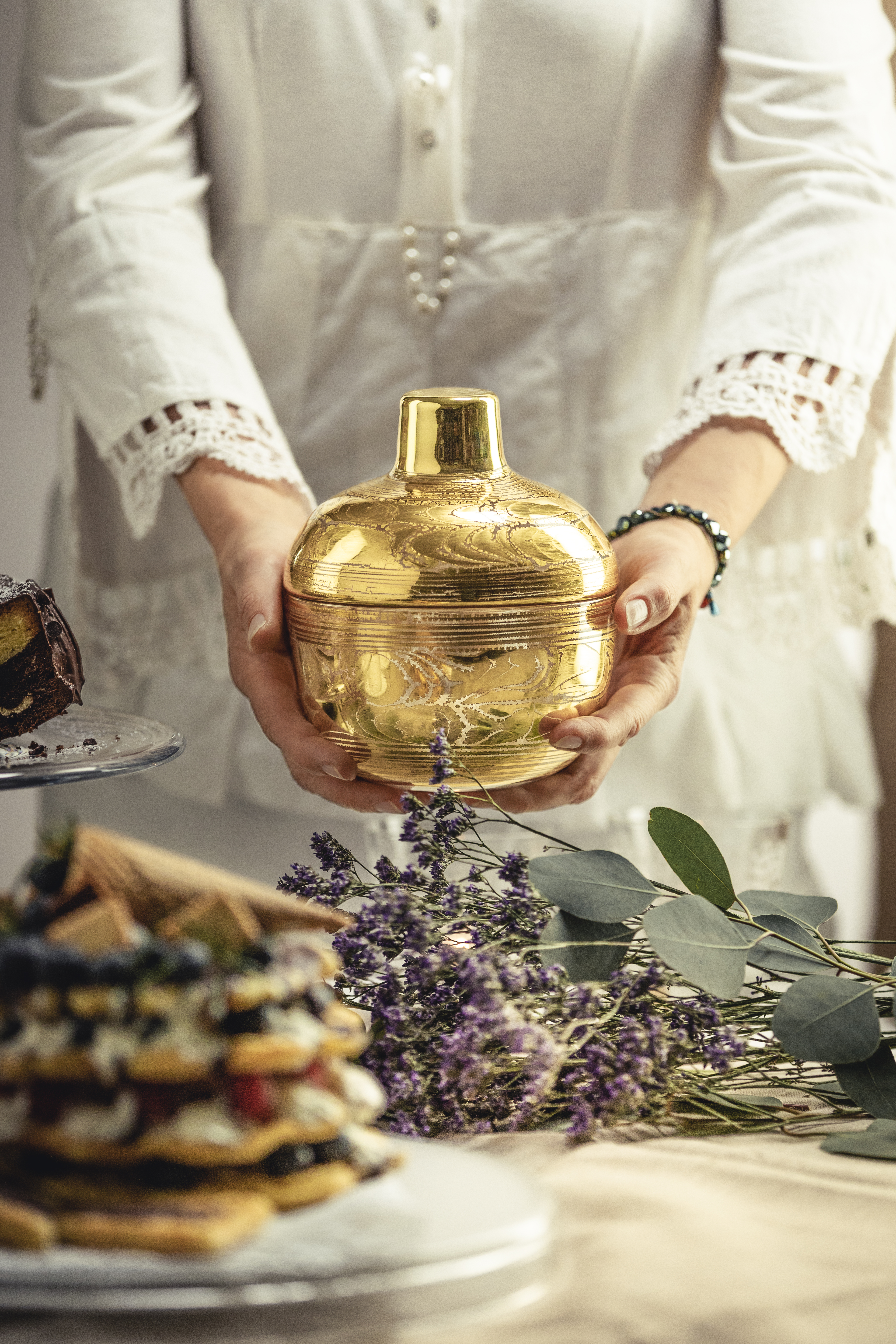 Hands holding a golden candy box