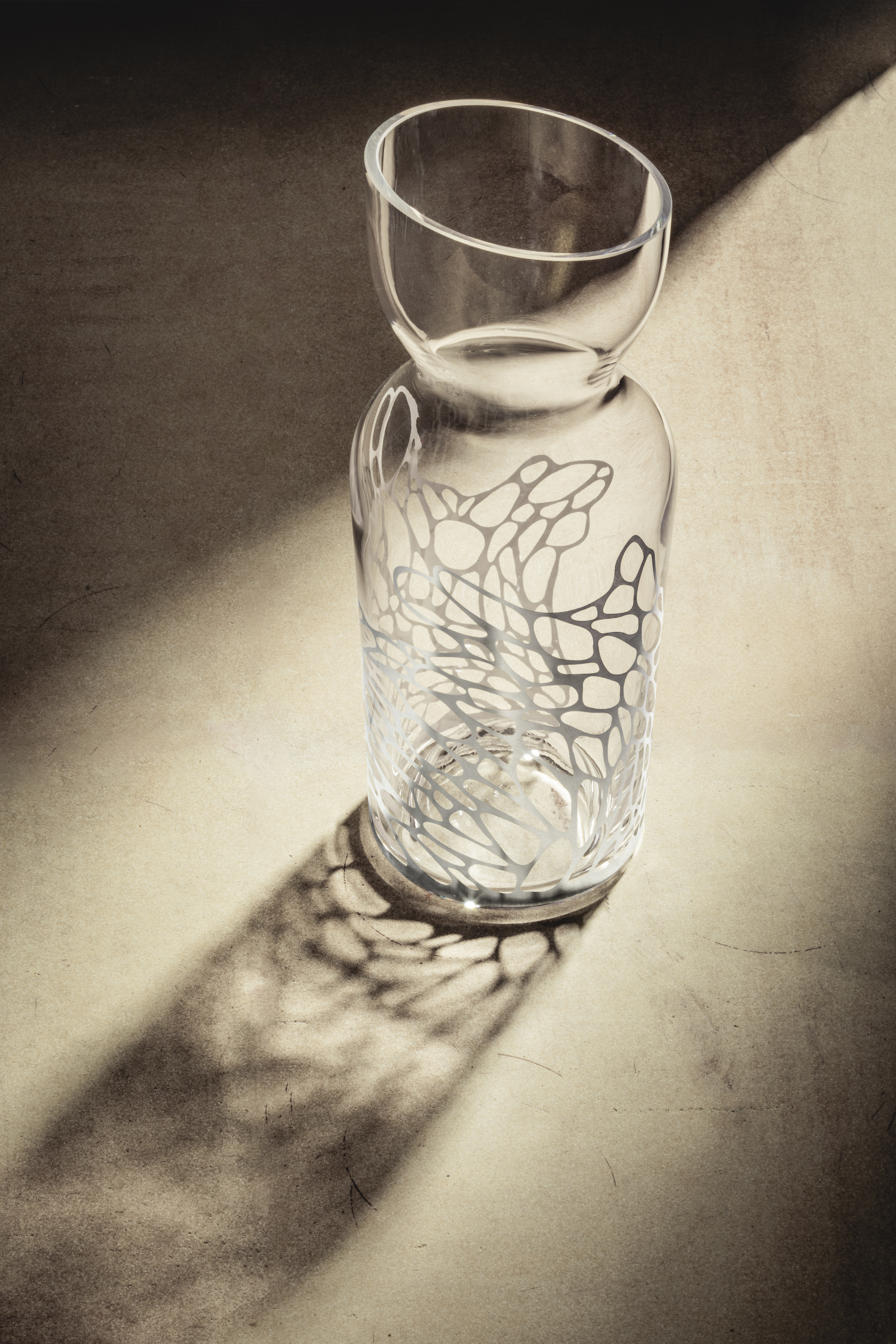 A carafe from the Net series in the light on a table