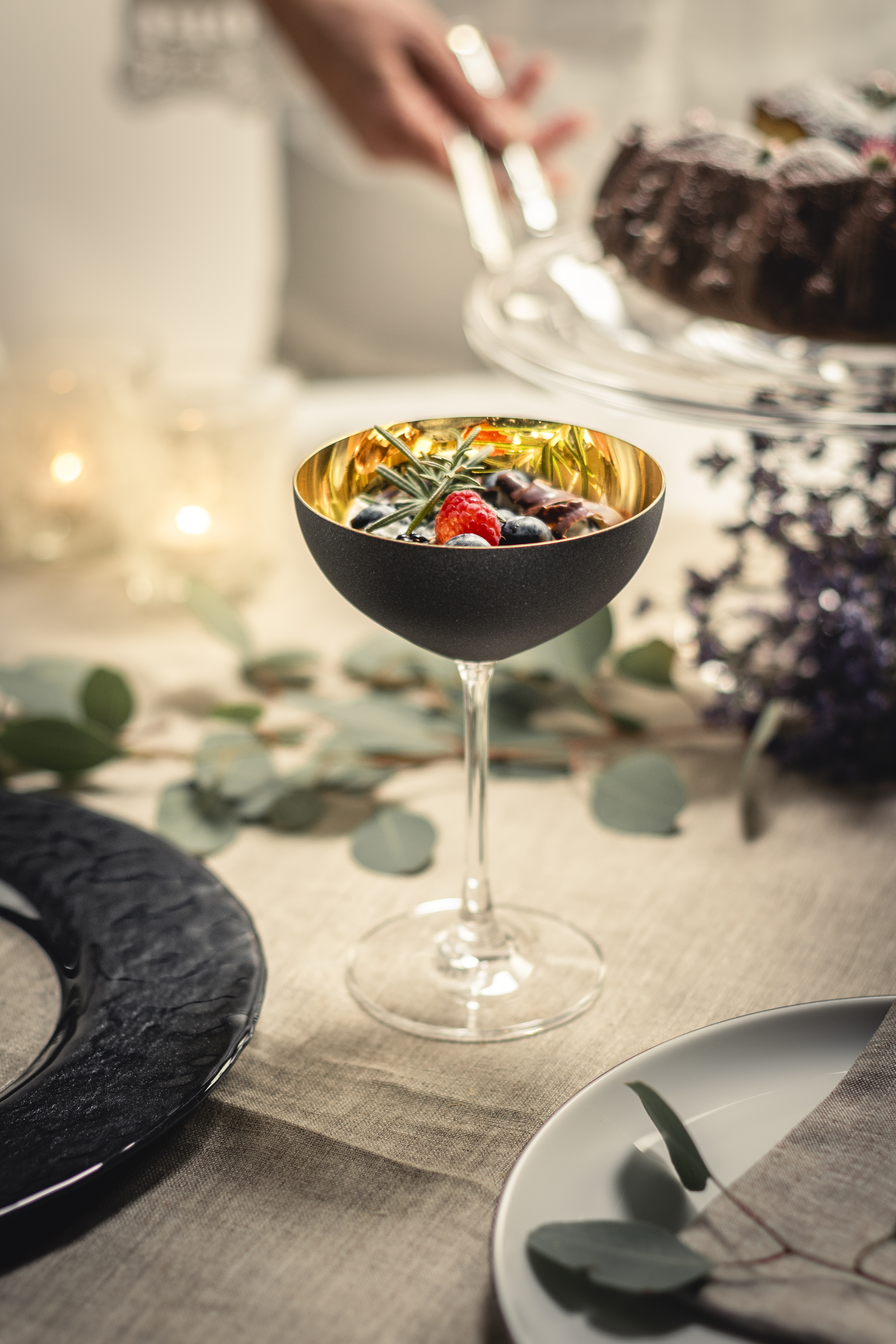 Gold/schwarzes Champagner Glas mit Früchten gefüllt