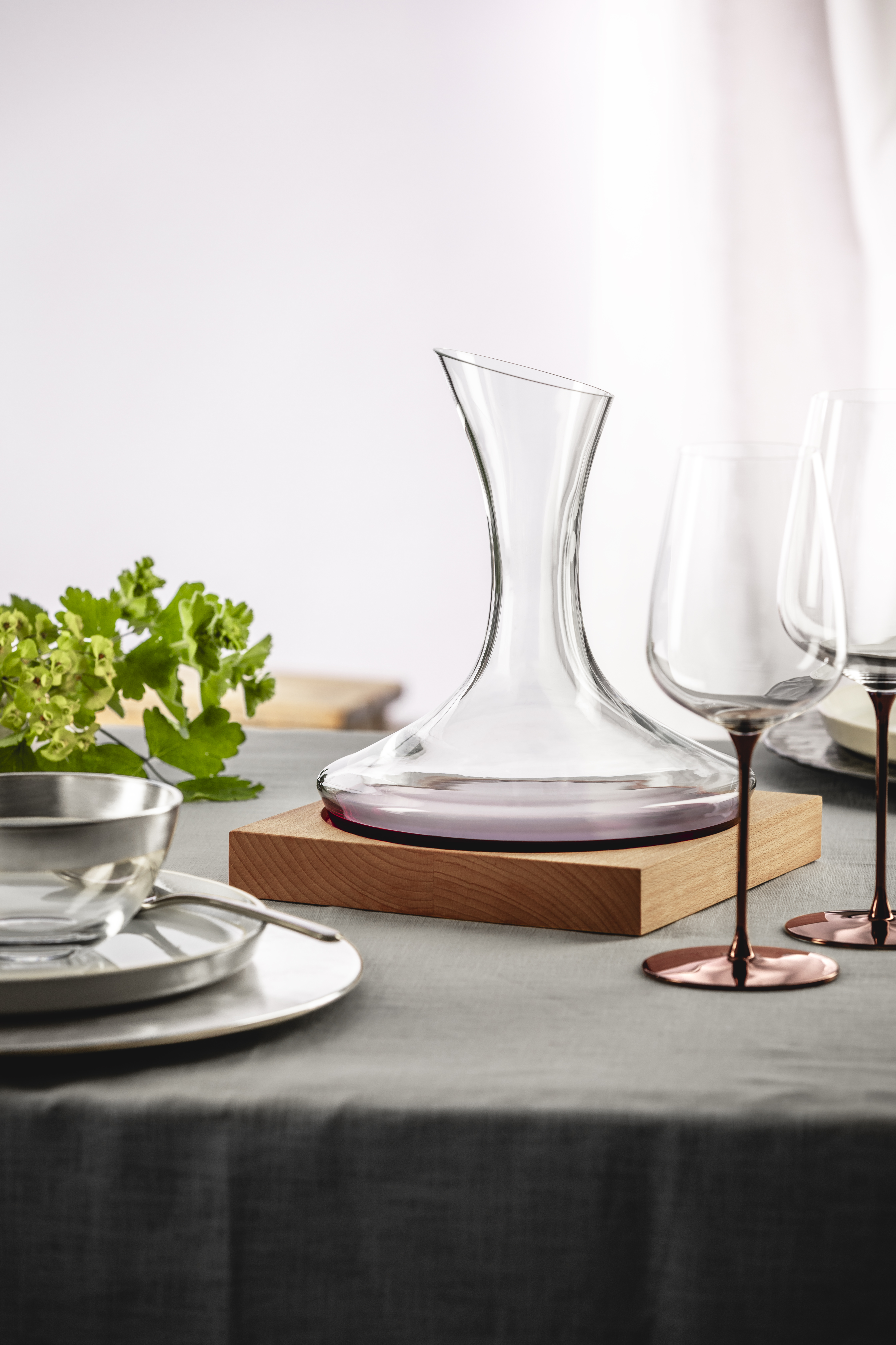 Decanter on wooden base with glasses on a table