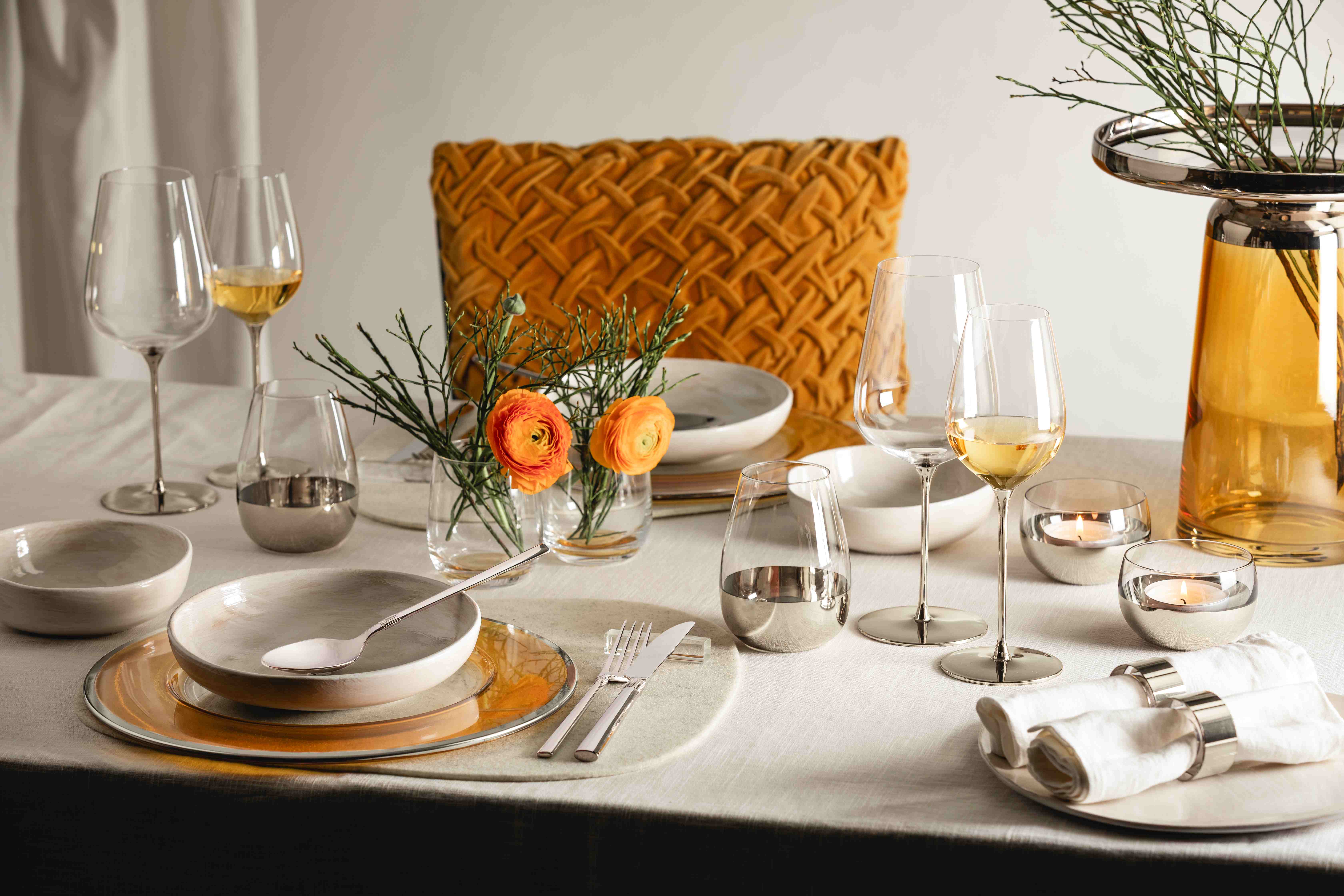 A lavishly set table in shades of platinum and orange.