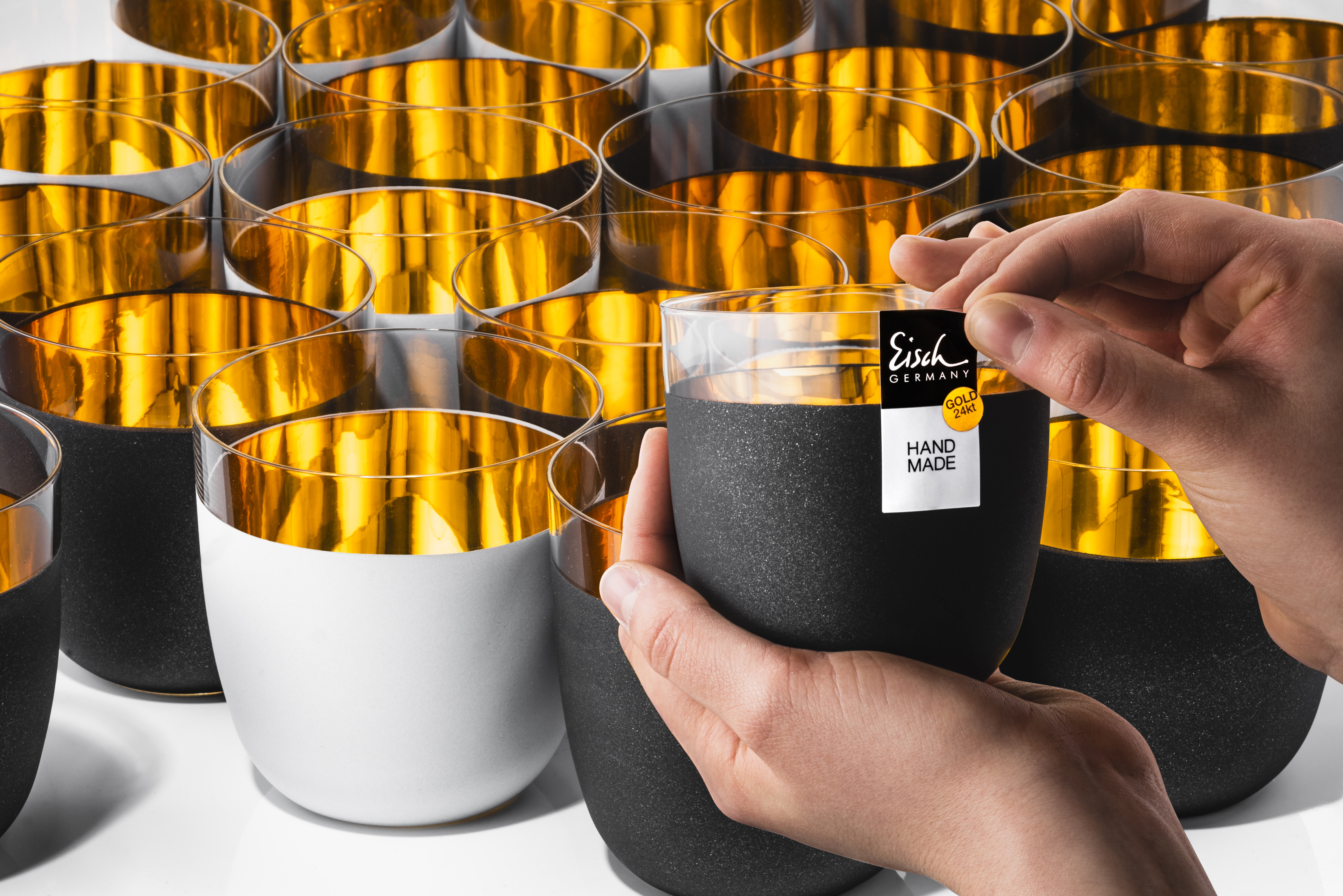 Hand with handmade sticker with black and white gold cups