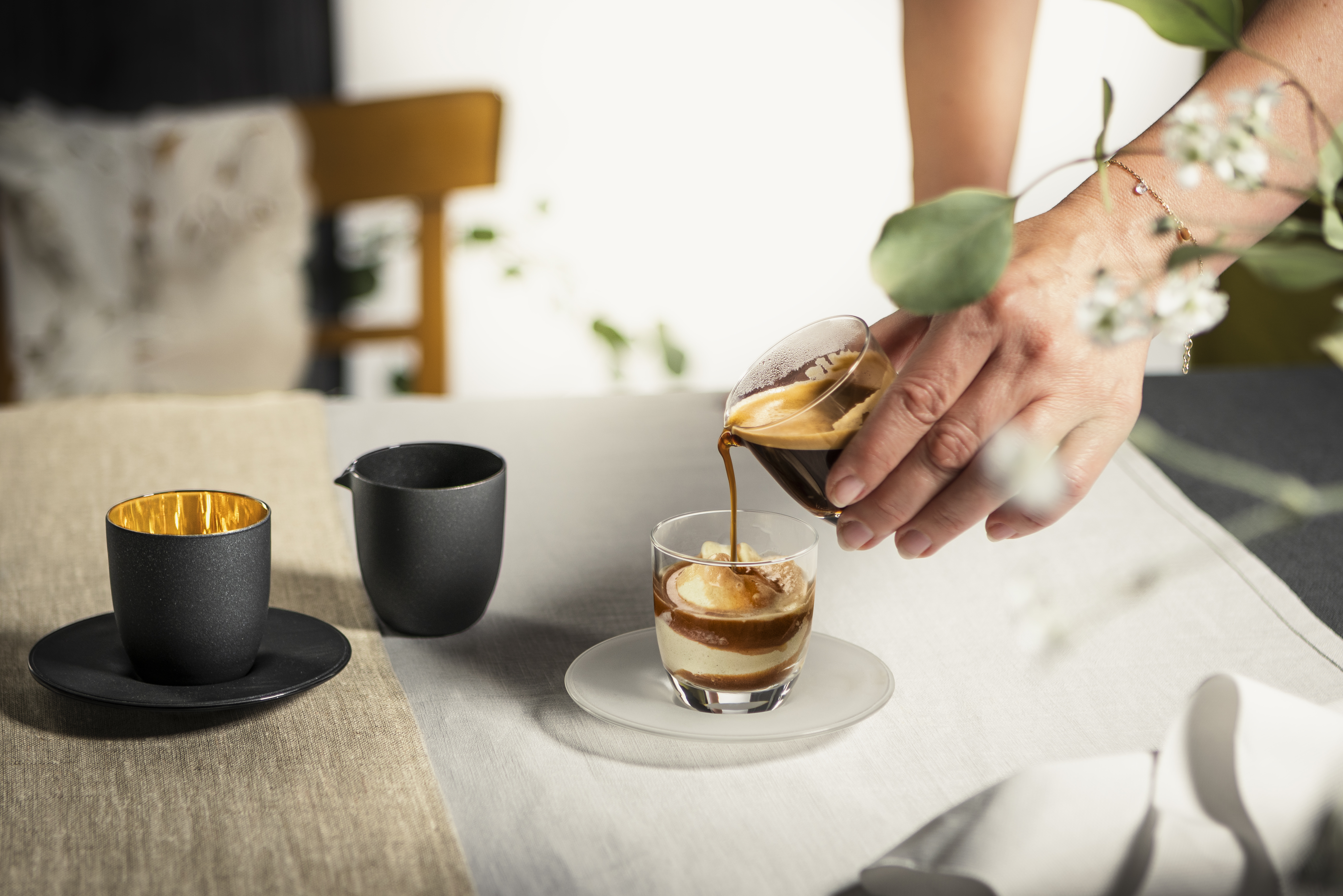Affogatoset in schwarz/gold und klar beim übergießen einer Eiskugel mit Espresso