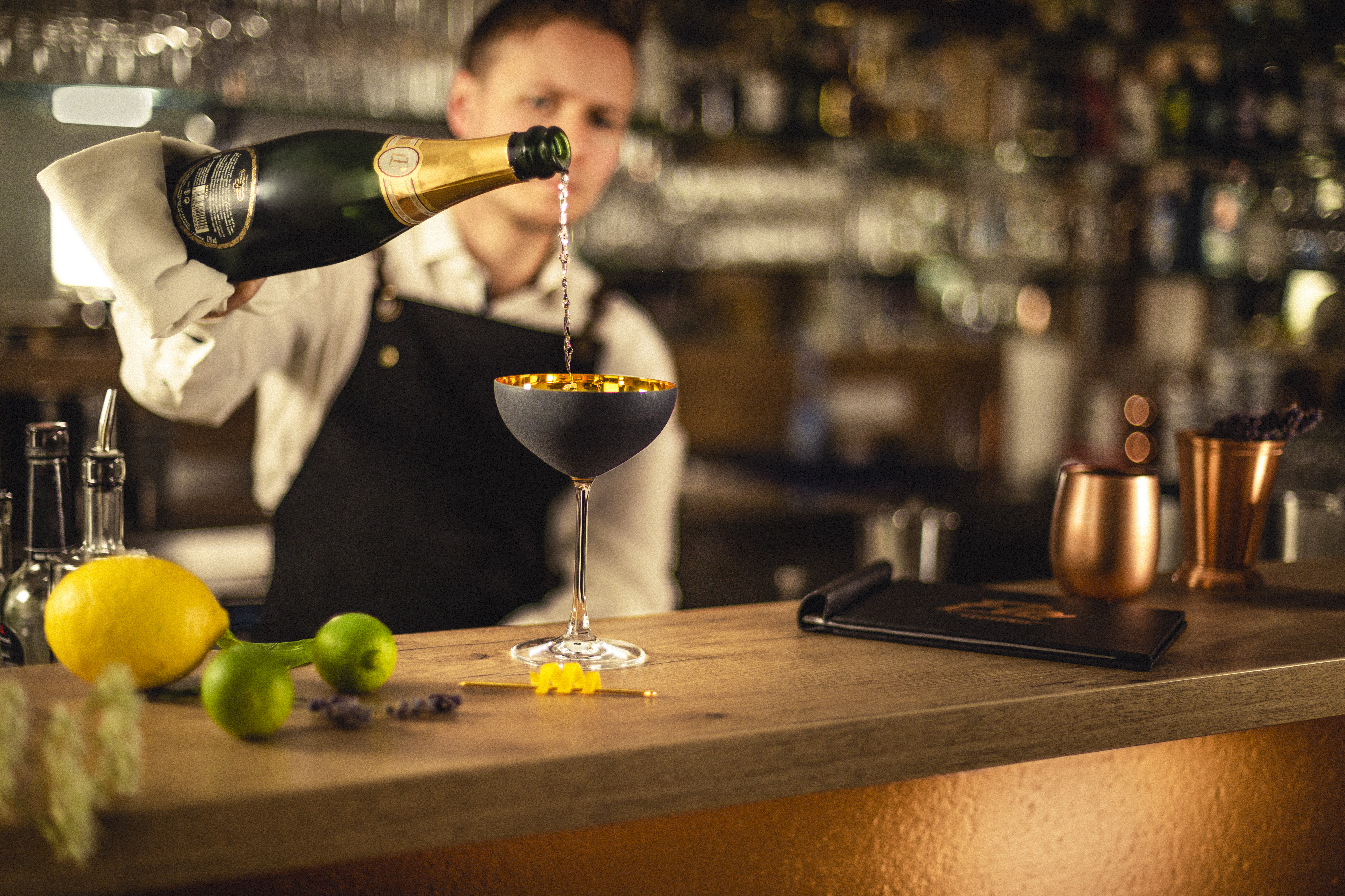 Bartender pouring sparkling wine into a champagne glass