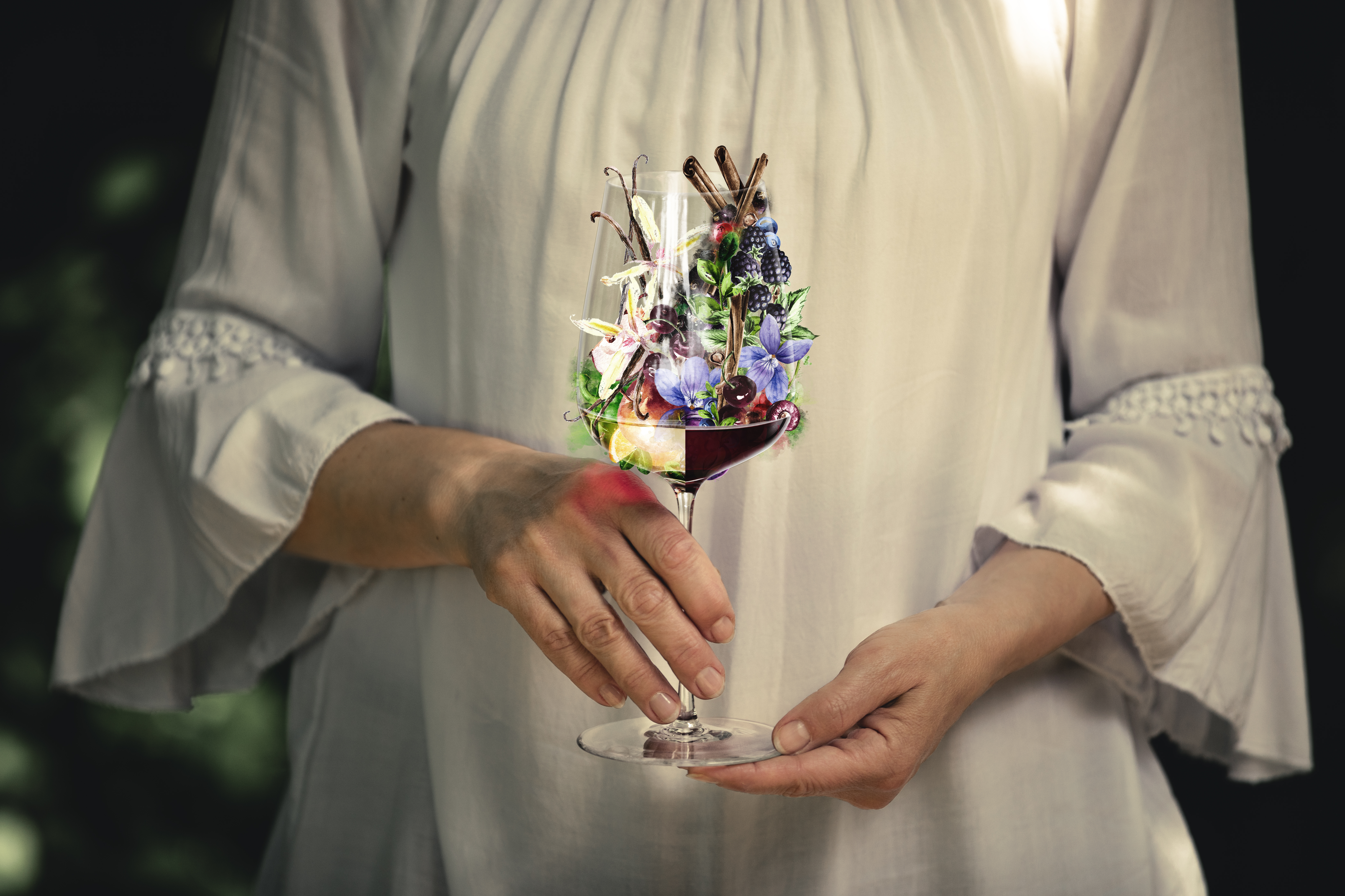 A person holding a glass with different aromas in it
