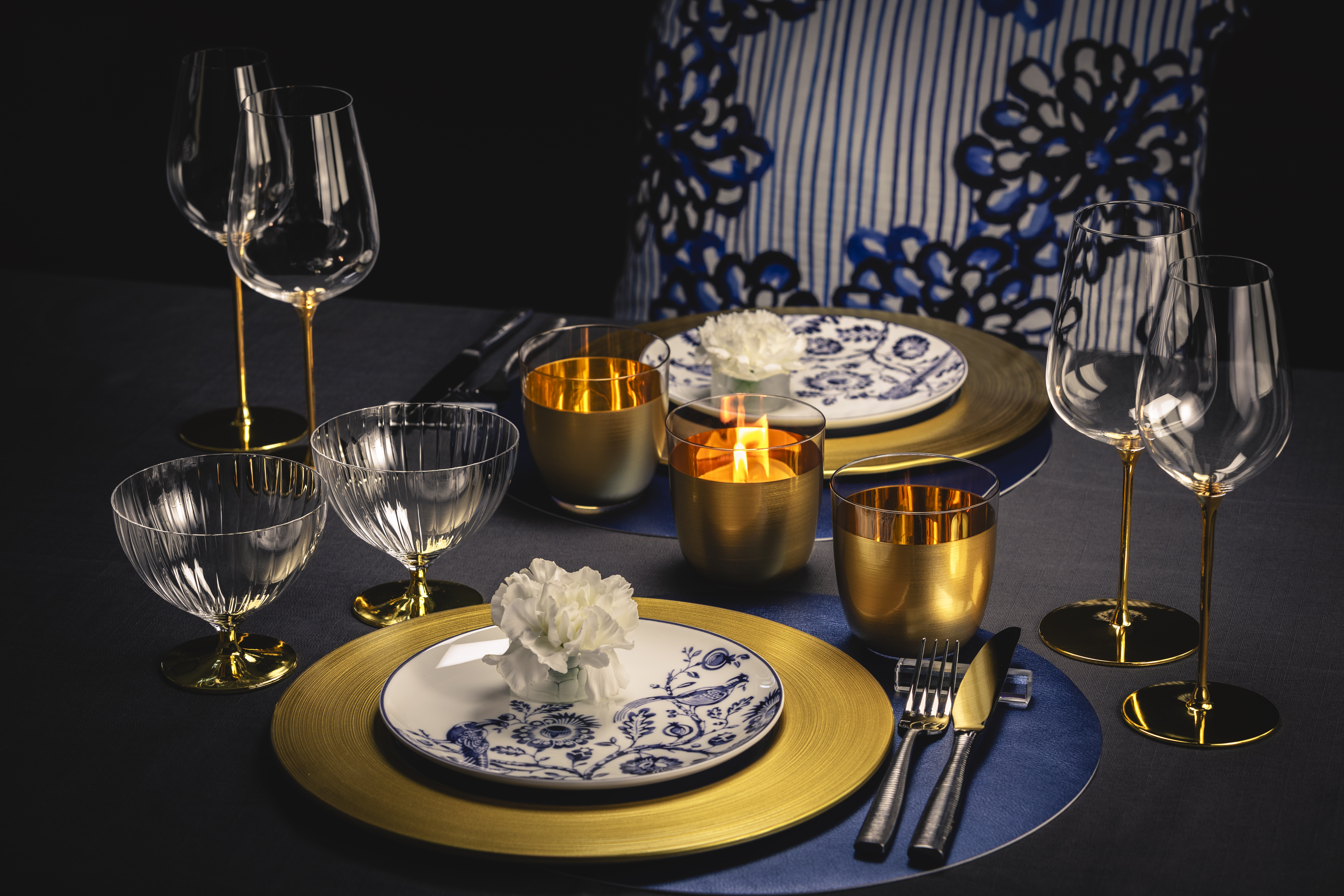 Table arrangement with golden glasses and porcelain and gold plates