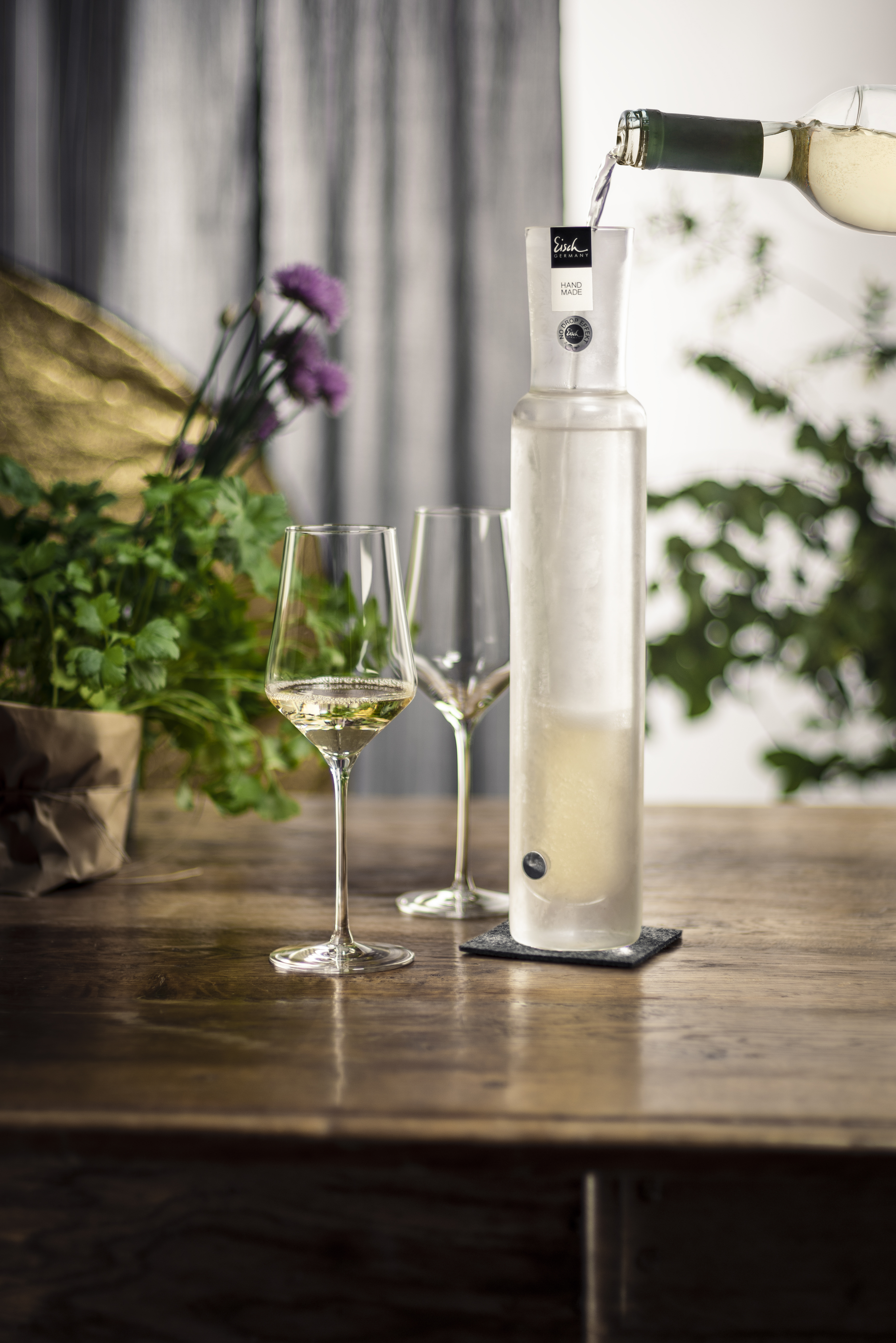 The Rapid Plus cooling decanter stands on a table with two glasses